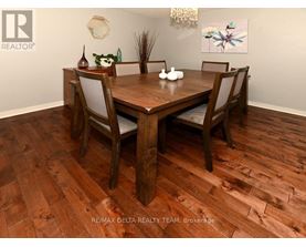 A dining room with a wooden table and chairs.