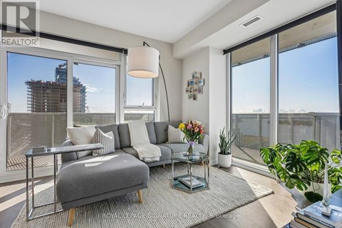 A living room with a grey sofa and a glass table.