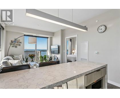 A modern living room with a marble countertop and a large window overlooking the water.