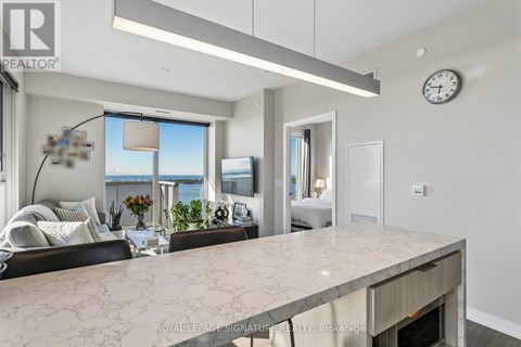 A modern living room with a marble countertop and a large window overlooking the water.