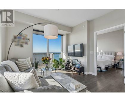 A living room with a large window overlooking the water.