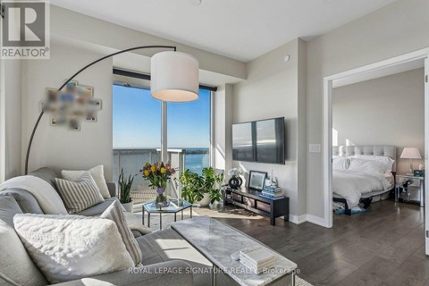 A living room with a large window overlooking the water.