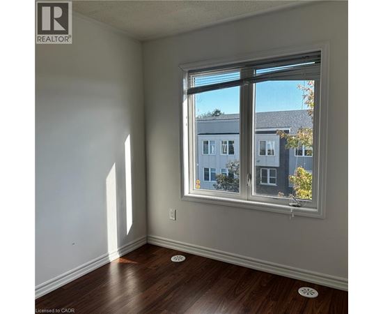 A room with a window showing a view of a building outside.