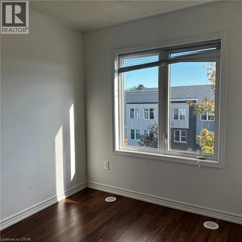 A room with a window showing a view of a building outside.