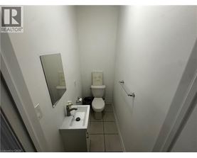 A bathroom with a toilet, sink, and mirror.