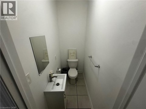 A bathroom with a toilet, sink, and mirror.
