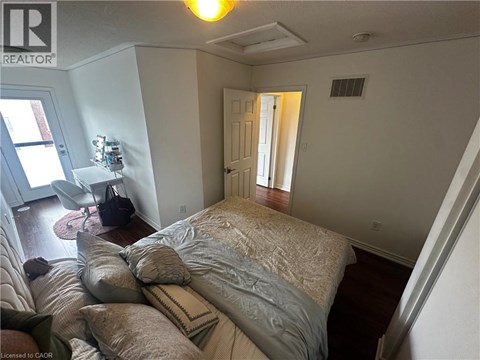 A bedroom with a bed, pillows, and a chair.
