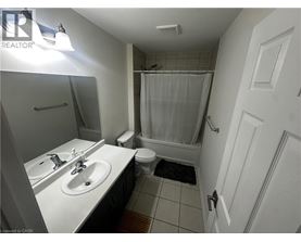 A bathroom with a white sink, toilet, and shower curtain.