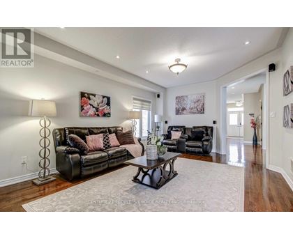 A living room with a black leather couch and a coffee table.
