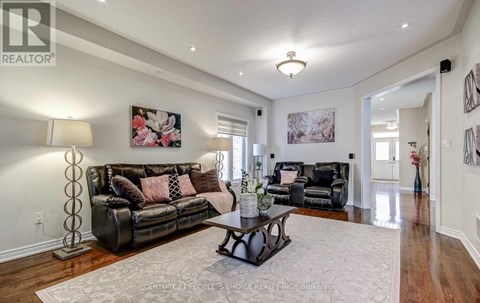 A living room with a black leather couch and a coffee table.
