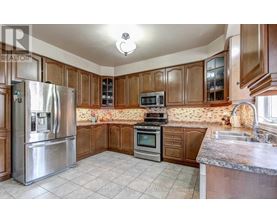 A kitchen with wooden cabinets and a stainless steel refrigerator.