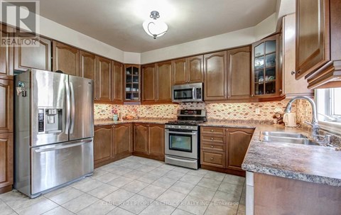 A kitchen with wooden cabinets and a stainless steel refrigerator.