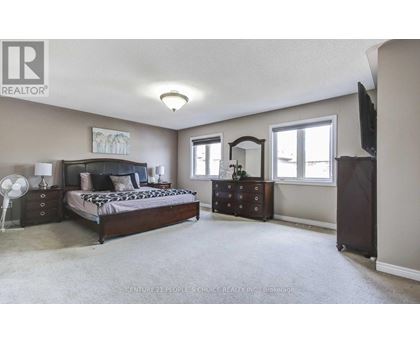 A bedroom with a bed, dresser, and mirror.