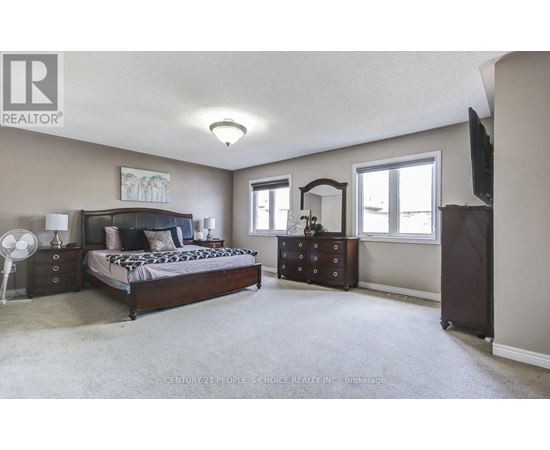 A bedroom with a bed, dresser, and mirror.
