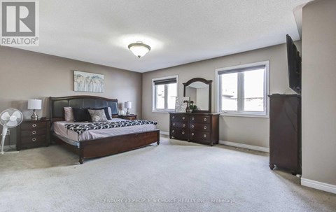 A bedroom with a bed, dresser, and mirror.