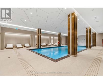 A large indoor swimming pool with a tiled floor and a tiled wall.
