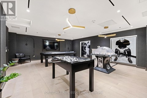 A room with a pool table and a foosball table.