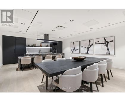 A dining room with a black table and white chairs.