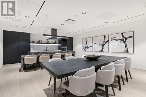 A dining room with a black table and white chairs.