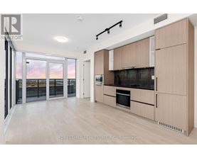 A modern kitchen with wooden cabinets and a stainless steel oven.