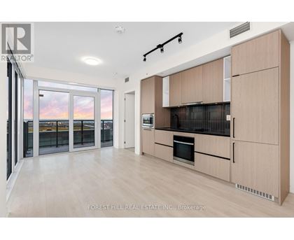 A modern kitchen with wooden cabinets and a stainless steel oven.