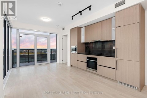 A modern kitchen with wooden cabinets and a stainless steel oven.