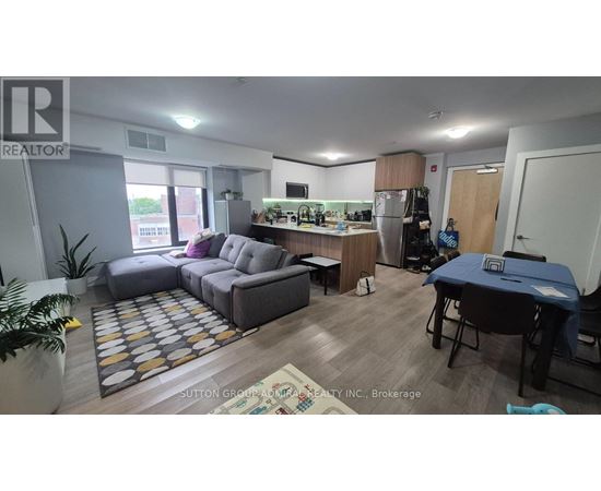 A living room with a grey sofa and a dining table.