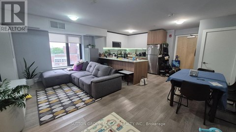 A living room with a grey sofa and a dining table.