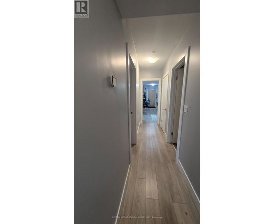A long hallway with wood floors and white walls.