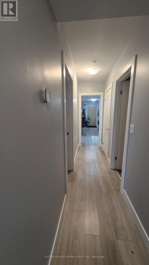 A long hallway with wood floors and white walls.