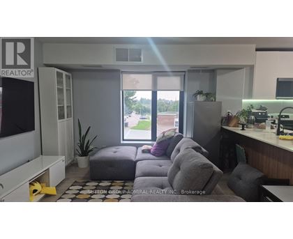 A realtor's office with a couch and a window showing an outdoor view.