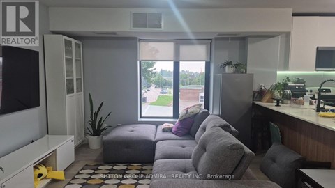 A realtor's office with a couch and a window showing an outdoor view.
