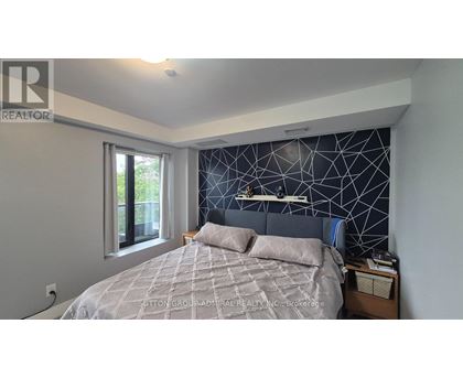 A bedroom with a bed, nightstand, and window.