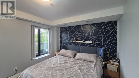 A bedroom with a bed, nightstand, and window.