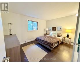 A bedroom with a bed, nightstand, and lamp.