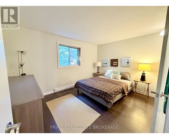 A bedroom with a bed, nightstand, and lamp.