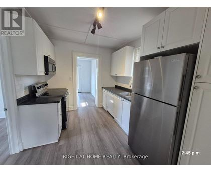 A kitchen with white cabinets and a stainless steel refrigerator.