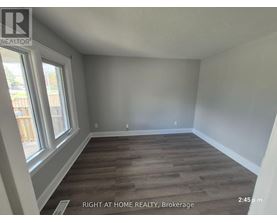 A room with wooden flooring and a window at the Brokerage of Right at Home Realty.
