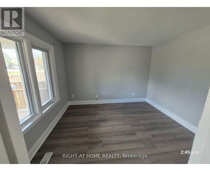 A room with wooden flooring and a window at the Brokerage of Right at Home Realty.