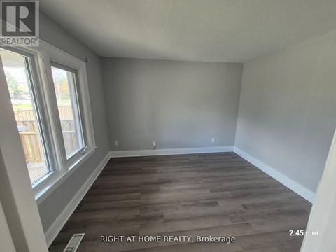 A room with wooden flooring and a window at the Brokerage of Right at Home Realty.