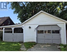 A garage with a white exterior and a grey door is shown.