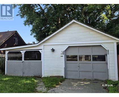 A garage with a white exterior and a grey door is shown.
