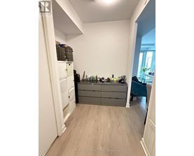 A kitchen with a white refrigerator, a wooden floor, and a blue chair.