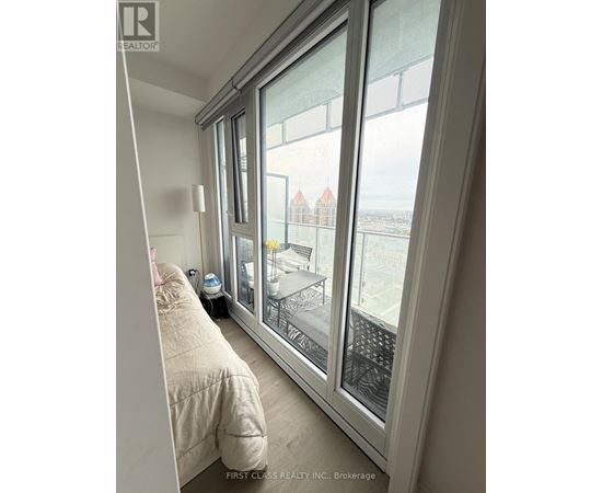 A bedroom with a large window overlooking a cityscape.