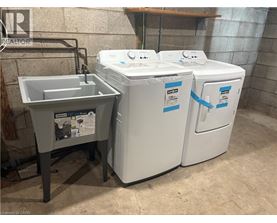 A washing machine and a sink are in a room.