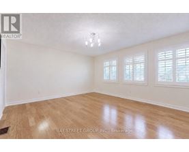 A room with wooden flooring and white walls.