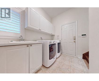 A kitchen with white cabinets and a white door.