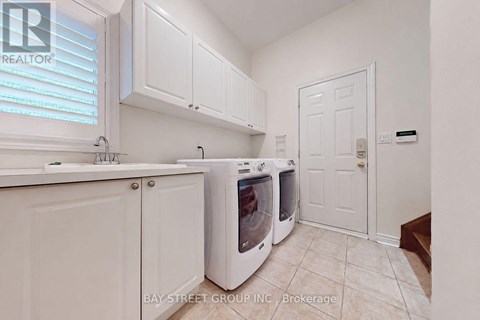 A kitchen with white cabinets and a white door.