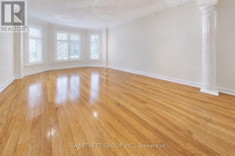 A spacious room with wooden flooring and white walls.