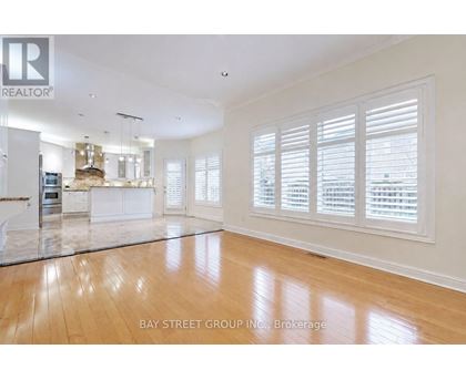 A spacious living room with wooden floors and white walls.